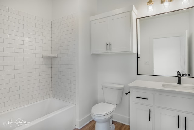 full bathroom featuring vanity, wood-type flooring, tiled shower / bath, and toilet