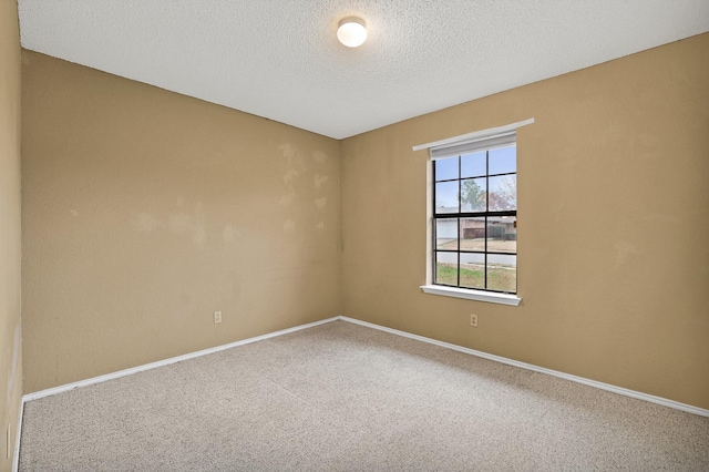 carpeted empty room with a textured ceiling