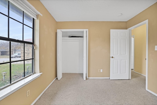 unfurnished bedroom with light colored carpet and a closet