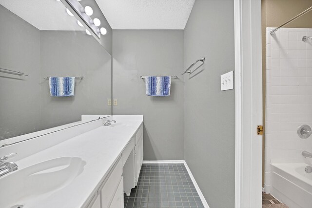 bathroom with bathtub / shower combination, vanity, a textured ceiling, and tile patterned flooring