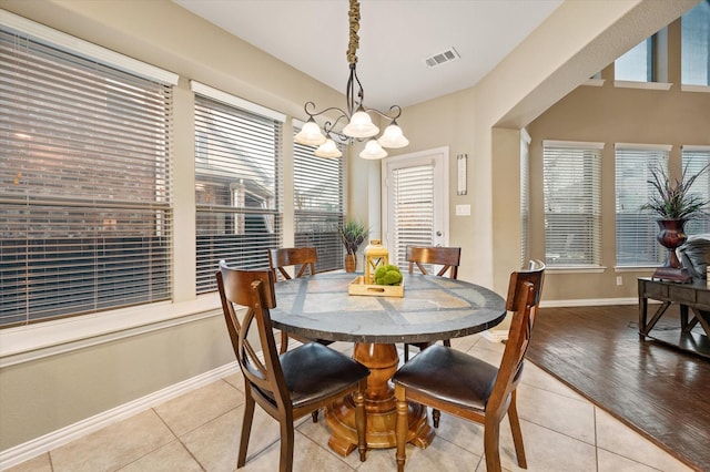 tiled dining area with a chandelier