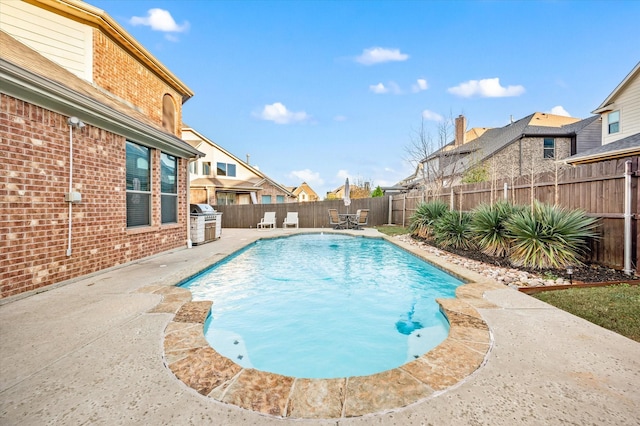 view of swimming pool featuring a grill and a patio area