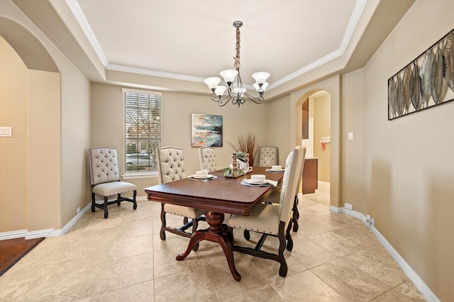 dining space featuring an inviting chandelier, light tile patterned floors, crown molding, and a tray ceiling