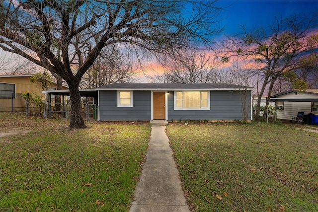 ranch-style house featuring a carport and a yard