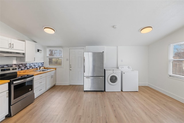 kitchen featuring white cabinets, independent washer and dryer, appliances with stainless steel finishes, and vaulted ceiling