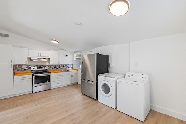 kitchen featuring tasteful backsplash, butcher block countertops, white cabinetry, stainless steel appliances, and washing machine and clothes dryer