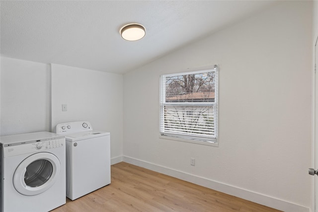 laundry area with light wood-type flooring and washing machine and dryer