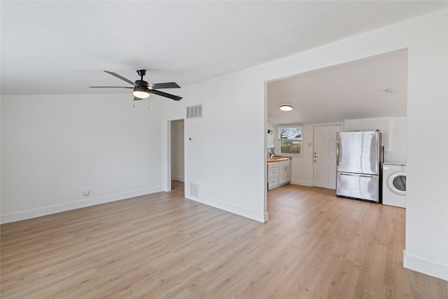 unfurnished living room featuring washer / clothes dryer, ceiling fan, and light hardwood / wood-style flooring