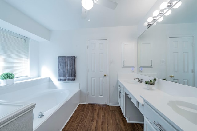 bathroom featuring vanity, hardwood / wood-style flooring, a bathtub, and ceiling fan