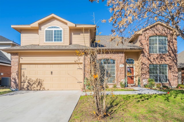 view of front of house featuring cooling unit, a front yard, and a garage