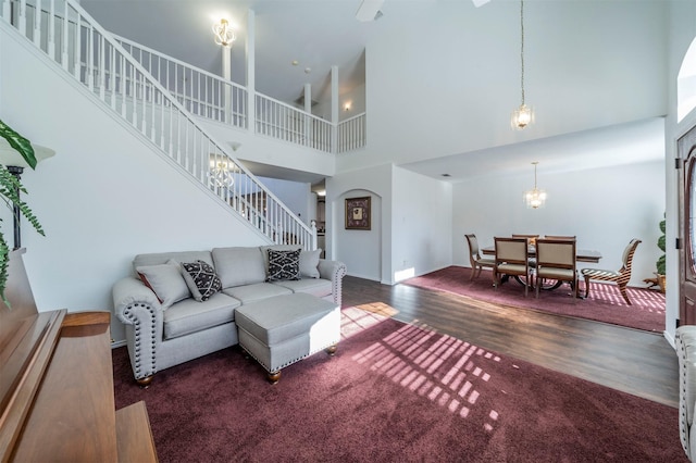 living room with dark hardwood / wood-style flooring and a towering ceiling