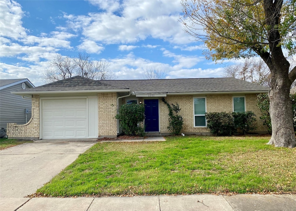 ranch-style home with a garage and a front lawn