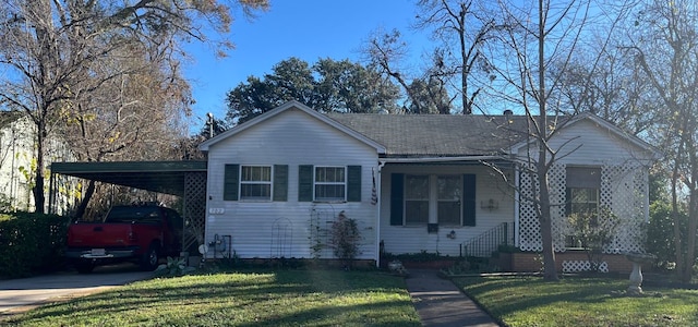 view of front of property with a front lawn and a carport