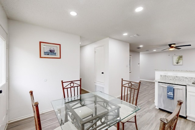 dining space featuring ceiling fan, a textured ceiling, and light wood-type flooring