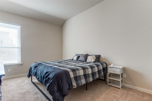 carpeted bedroom featuring vaulted ceiling and multiple windows