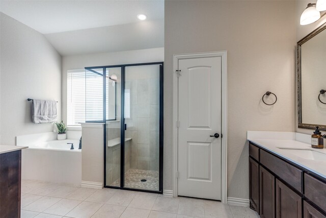 bathroom featuring tile patterned flooring, vanity, vaulted ceiling, and shower with separate bathtub