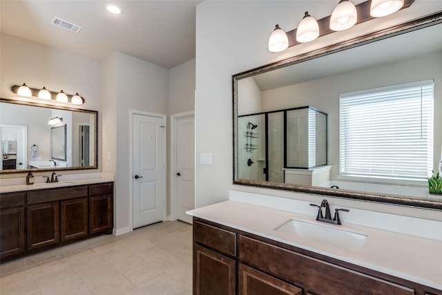 bathroom featuring tile patterned floors, a shower with door, and vanity