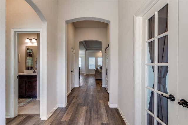 corridor featuring sink and dark wood-type flooring