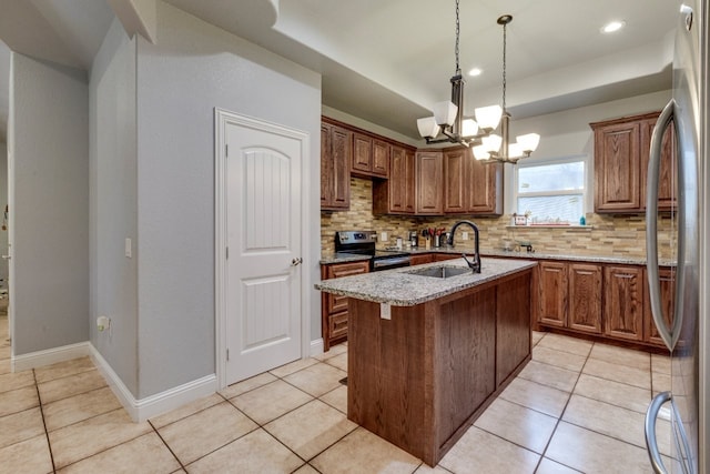 kitchen featuring light stone counters, light tile patterned flooring, appliances with stainless steel finishes, and a center island with sink