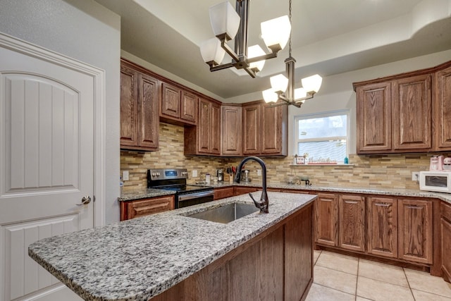 kitchen with sink, stainless steel electric range oven, hanging light fixtures, a center island with sink, and a notable chandelier