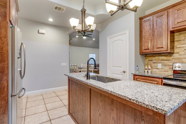 kitchen with sink, stainless steel appliances, tasteful backsplash, a notable chandelier, and decorative light fixtures