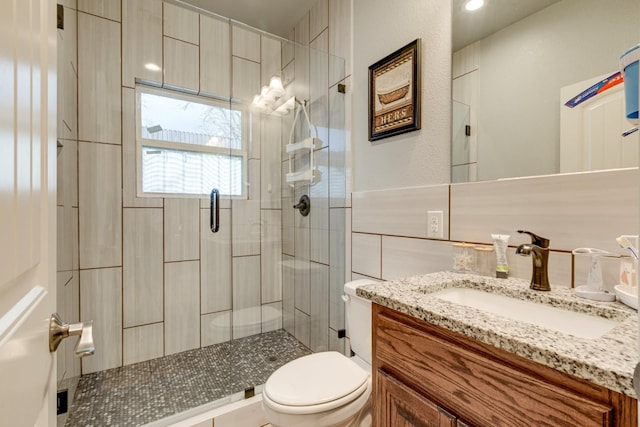 bathroom with vanity, a shower with shower door, and toilet