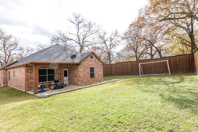 rear view of house featuring a yard and a patio