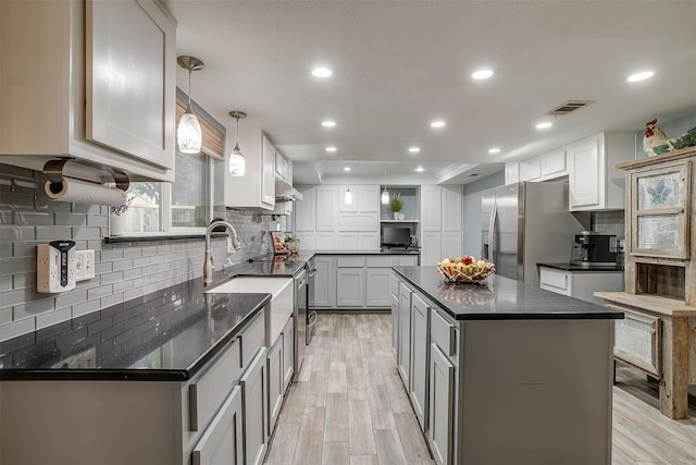 kitchen featuring open shelves, tasteful backsplash, recessed lighting, appliances with stainless steel finishes, and light wood-type flooring