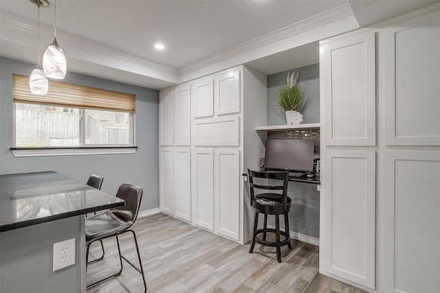 office area with light wood-type flooring and crown molding