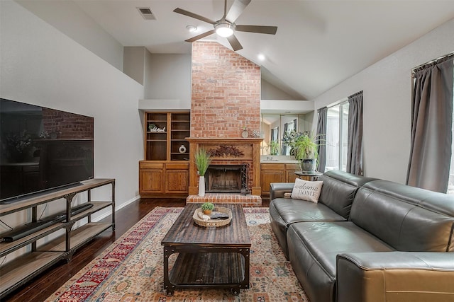 living room featuring ceiling fan, dark wood-type flooring, vaulted ceiling, and a brick fireplace