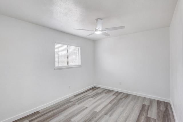 spare room with ceiling fan, a textured ceiling, and light wood-type flooring