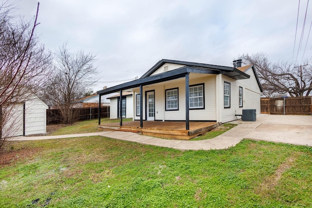 view of front of property with a front yard, a deck, and central air condition unit