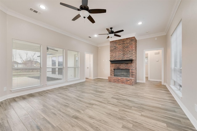 unfurnished living room with ceiling fan, crown molding, light wood-type flooring, and a brick fireplace