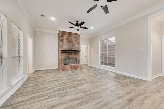 unfurnished living room featuring ceiling fan, ornamental molding, a fireplace, and light hardwood / wood-style floors