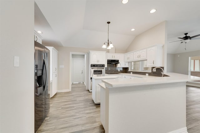 kitchen featuring appliances with stainless steel finishes, tasteful backsplash, white cabinets, hanging light fixtures, and kitchen peninsula