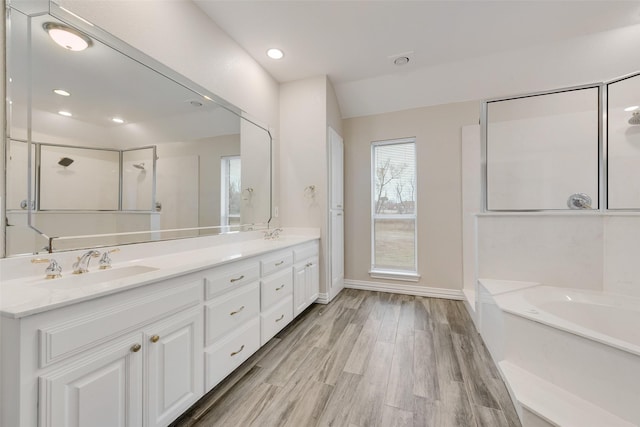 bathroom featuring wood-type flooring, separate shower and tub, and vanity