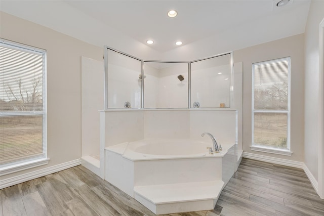 bathroom featuring hardwood / wood-style flooring and plus walk in shower