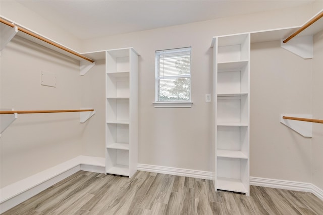 walk in closet with light hardwood / wood-style flooring