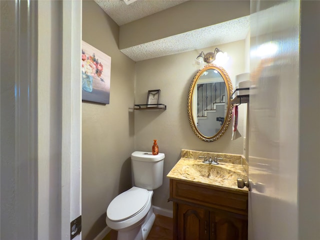 bathroom with vanity, a textured ceiling, and toilet