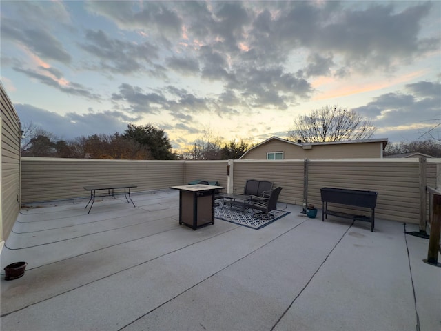 patio terrace at dusk featuring a fire pit