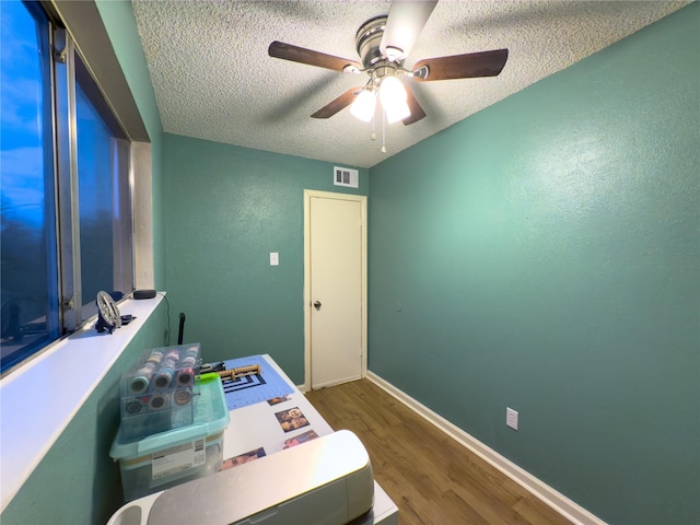 office area with ceiling fan, hardwood / wood-style floors, and a textured ceiling