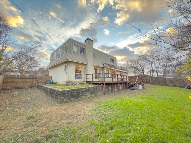 back of house with a wooden deck, a fenced backyard, a chimney, stairway, and a yard