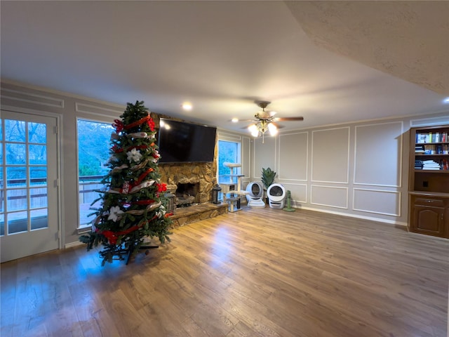 unfurnished living room with hardwood / wood-style floors, ceiling fan, and a fireplace