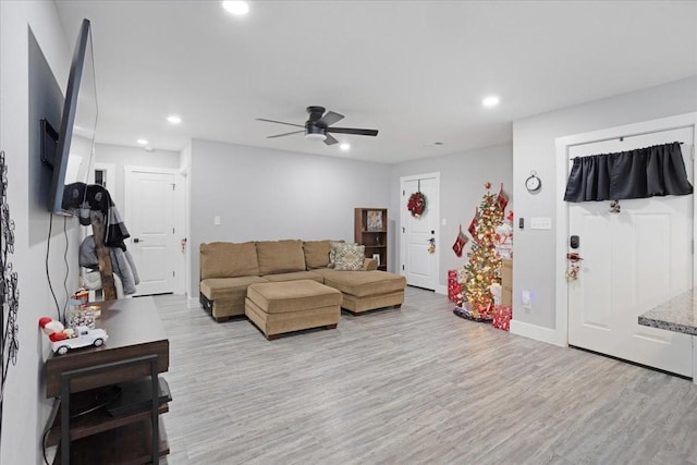 living room with light hardwood / wood-style flooring and ceiling fan