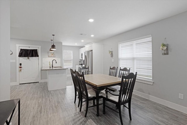 dining room featuring hardwood / wood-style floors, sink, and a wealth of natural light