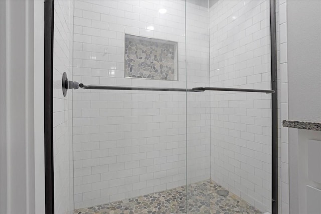 bathroom with a shower with door