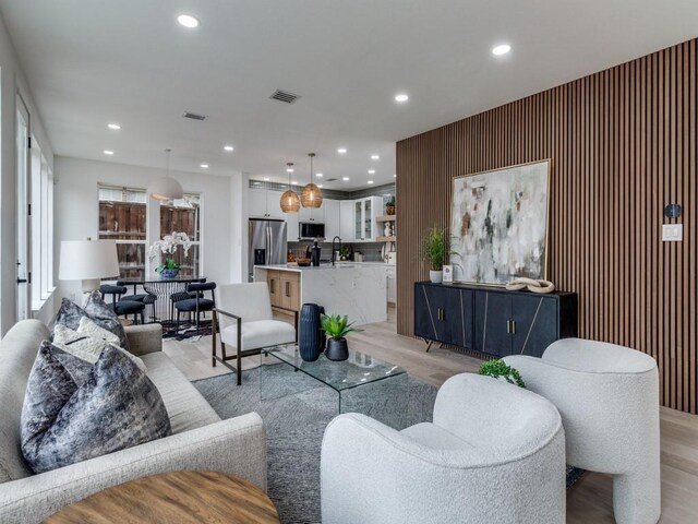 dining space featuring a fireplace, light wood-type flooring, and sink