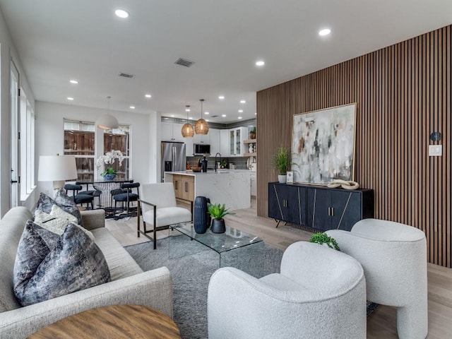 living room featuring sink and light hardwood / wood-style floors