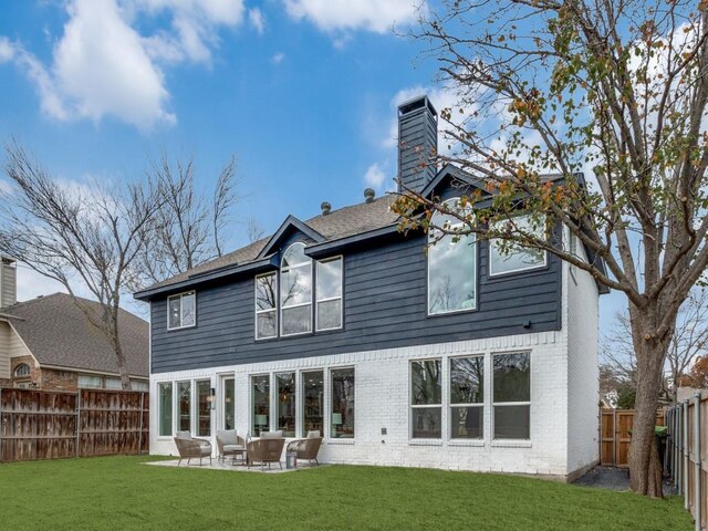 rear view of house featuring a yard, a patio, and an outdoor hangout area