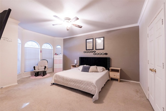 carpeted bedroom with ornamental molding and ceiling fan